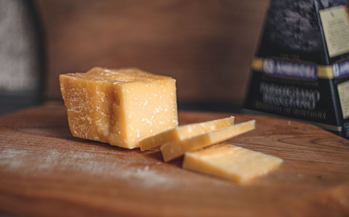 Una punta di Parmigiano Reggiano su un tagliere di legno