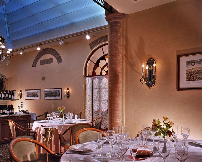 Tavoli apparecchiati sotto il lucernario del ristorante Il Correggio